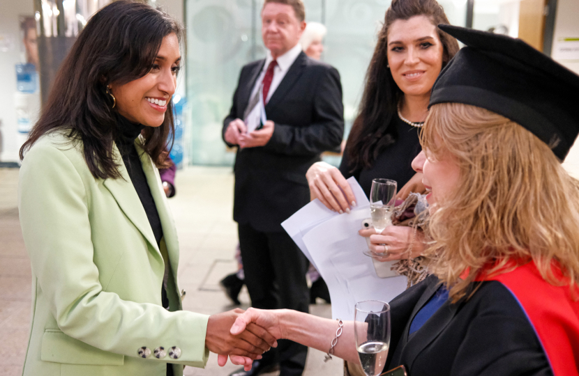 Claire shakes the hand of a graduate at East Surrey College.