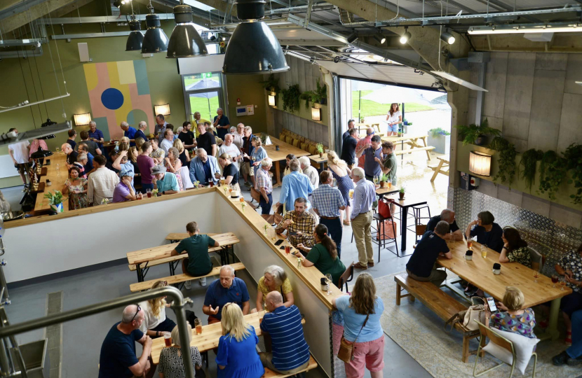A mingling crowd at the opening of the Titsey Taproom