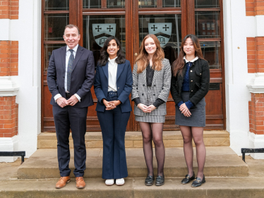 Claire stands outside Caterham School with Mr Jones, Danielle and Paige.