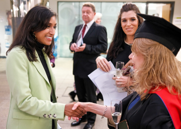 Claire shakes the hand of a graduate at East Surrey College.